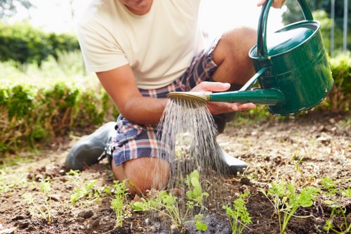 Gardener using correct manual handling techniques with heavy garden materials