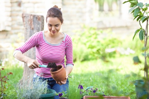 Professional gardener in Canning Town using PPE during outdoor work